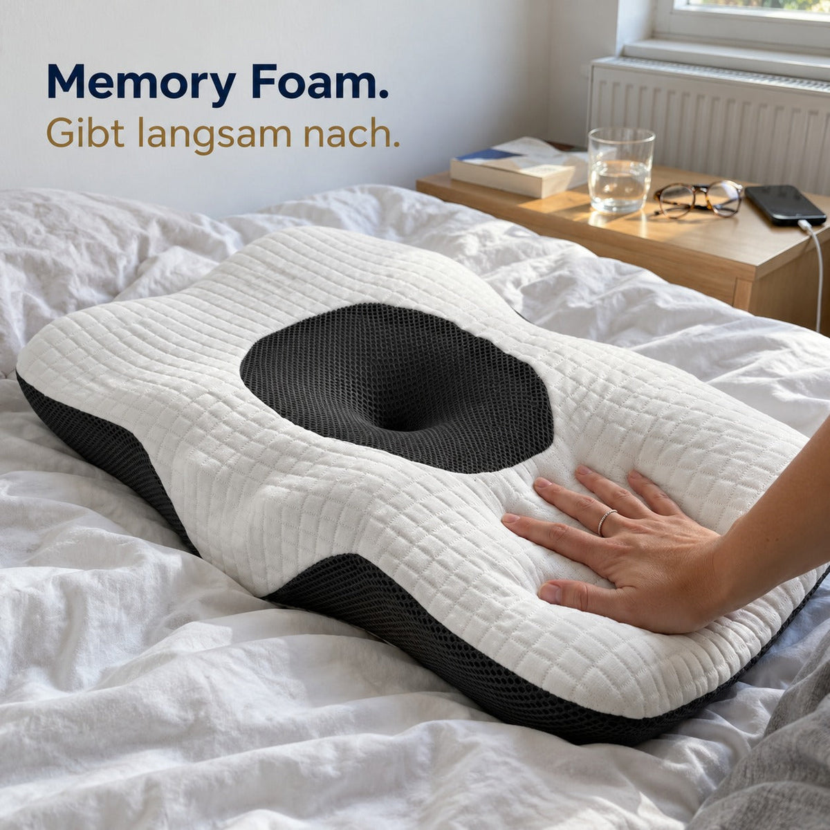 Hand drückt in den Memory Foam eines Kissens